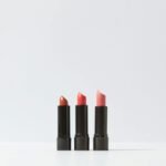 A minimalist display of three lipsticks on a white background, perfect for cosmetic themes.